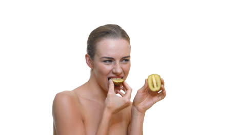 Beautiful-woman-eating-ripe-kiwi-while-topless-on-white-background