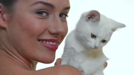 Portrait-of-smiling-beautiful-woman-with-white-kitty-on-white-studio-background