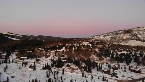 Low-slow-aerial-flight-over-the-snow-covered-Granby,-Colorado-America-at-sunset
