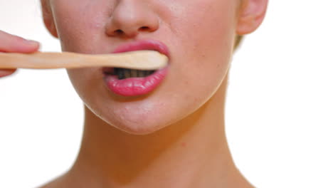 Frau,-Die-Ihre-Zähne-Mit-Einer-Bambuszahnbürste-Und-Schwarzer-Kohlenstoffzahnpasta-Putzt