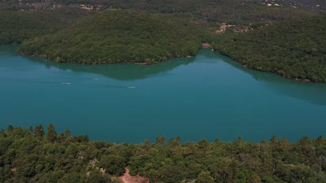 Aerial-view-above-canoe,-kayak-rowers-training-in-woodland-lake-waters