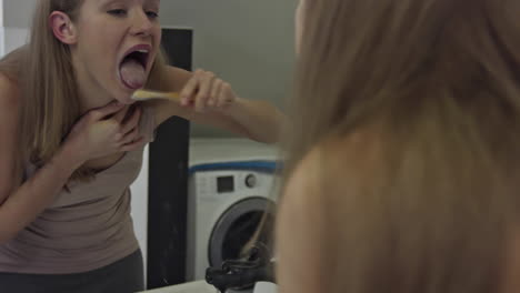 A-woman-washes-her-tongue-with-a-bamboo-toothbrush