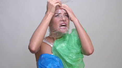 A-terrified-woman-wrapped-in-plastic-trash