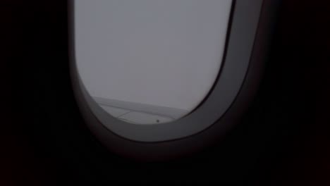 Blick-Auf-Den-Himmel-Aus-Der-Flugzeugkabine-Beim-Fliegen-über-Die-Wolkenhimmellandschaft-Durch-Das-Fenster-Mit-Flügelansicht-Tagsüber