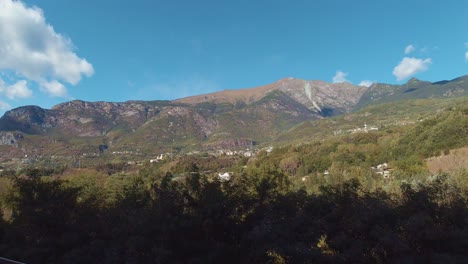Una-Vista-Tranquila-Desde-La-Carretera-De-Eslovenia-De-Valles-Escénicos-Con-Enormes-Montañas,-Bosques-Verdes-Y-Ríos-Verdes-Que-Fluyen-Bajo-El-Cielo-Azul-Cristalino-Con-Nubes-Blancas