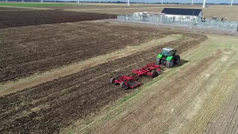 An-aerial-view-from-the-drone-as-it-circles-a-tractor-tilling-the-land-following-the-harvest-and-prepares-it-for-the-next-crop