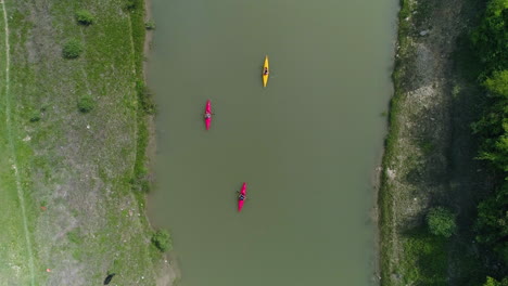 Kayaks-traveling-down-river-in-Kosovo,-Top-Down-Aerial