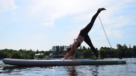 Yoga-Fitte-Frau-Auf-Paddelbrett,-Die-Beinstreckung-Macht