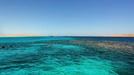 People-on-vacation-snorkeling-and-swimming-in-crystal-clear-blue-water,-diving-in-Egypt,-60-fps