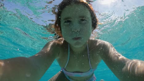 Unterwasser-Selfie-Eines-Hübschen-Kleinen-Rothaarigen-Mädchens,-Das-Den-Atem-Anhält,-Während-Es-In-Transparentes-Meerwasser-Eintaucht