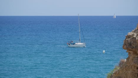 Close-up-beautiful-sailing-boat-on-blue-waters-next-to-coast