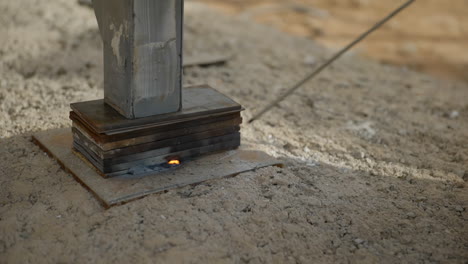 Slow-motion-construction-worker-welding-steel-modular-home-foundation-making-fiery-sparks