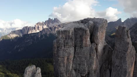 Cinque-Torri-towers-in-Dolomites-with-mountain-landscape-background,-cinematic-aerial-close-up