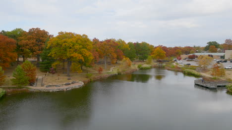 Aerial-view-of-beautiful-pond-and-park-with-trees-at-peak-Fall-color-in-Kirkwood-in-St