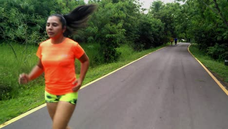 Tracking-Shot-Of-Girl-Wearing-Sportswear-Jogging-Front-Back-On-Rural-Street,-Asunction