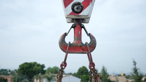 Strong-steel-chained-crane-pulley-with-weathered-red-paint-lifting-heavy-equipment