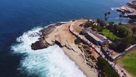Circle-aerial-view-of-La-Jolla-as-people-watch-sea-lions-swim-and-catch-sun-rays-on-the-rocks