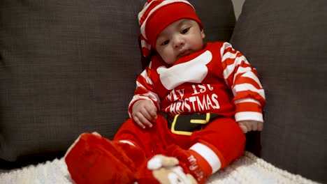 Adorable-Cute-Two-Month-Old-Baby-In-Festive-Red-Christmas-Outfit-Sitting-On-Couch