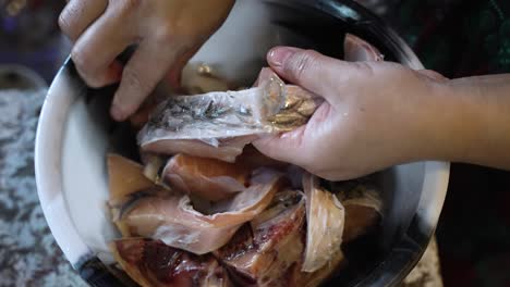 Overhead-View-Of-Female-Chef-Hands-Peeling-Scales-Off-Fresh-Fish-In-Bowl