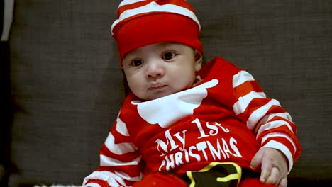 Adorable-Cute-Two-Month-Old-Baby-In-Festive-Red-Christmas-Outfit-Slouched-On-Couch