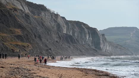 Gente-En-Dorset-Explorando-La-Ladera-De-La-Colina-De-La-Playa-Junto-Al-Agua