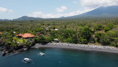 High-sweeping-panoramic-view-of-a-small-coastal-fishing-village-with-a-volcanic-mountain-view