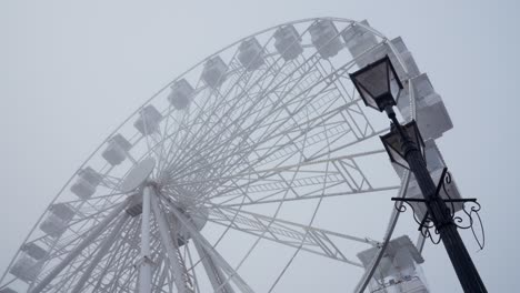 Flashing-Ferris-wheel-and-Victorian-lamppost-on-a-foggy-winter-day
