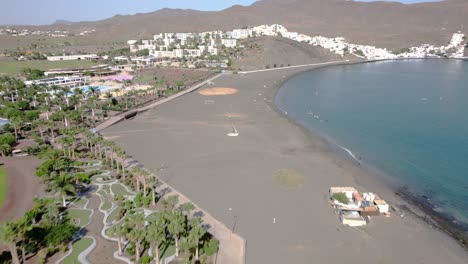 Aerial-view-along-the-Fuerteventura-beach-approaching-the-Playitas-Resort,-Spain