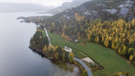 Kleine-Norwegische-Kirche-In-Einem-Herbstfarbenen-Tal,-Niedrige-Wolken,-Nebel-Und-Regen