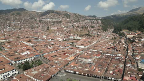 Wide-revealing-aerial-shot-of-Cusco,-Peru-during-a-bright-sunny-day