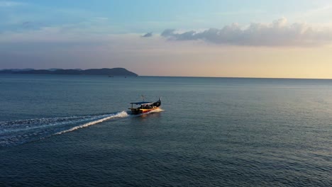 Exotic-seascape,-cinematic-aerial-shot-drone-fly-around-a-traditional-fishing-boat-sailing-on-the-sea,-out-and-about-to-catch-some-wild-fishes-at-sunset-golden-hour