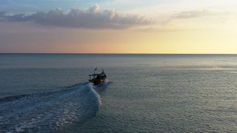 Filmische-Landschaftsansicht-Eines-Traditionellen-Fischerboots,-Das-Auf-Der-Andamanensee-Zur-Goldenen-Stunde-Des-Wunderschönen-Sonnenuntergangs-Segelt,-Luftfahrt