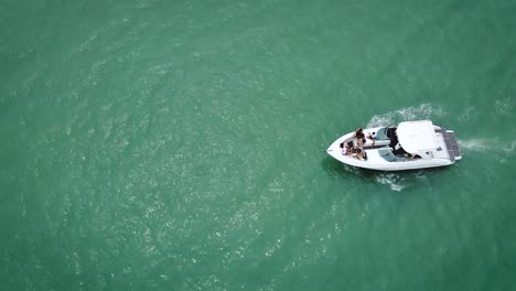 Overhead-Shot-Of-White-Boat-Sailing-Into-Open-Blue-Ocean-Towards-His-Destination,-Totoritas