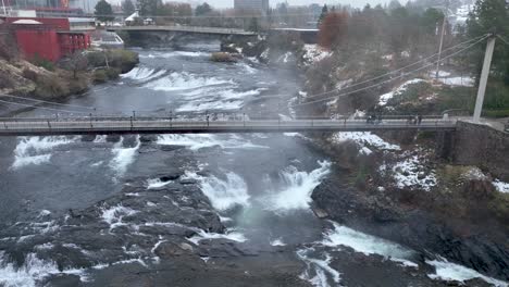 Aerial-view-of-a-pedestrian-bridge-over-the-Spokane-Falls-during-a-cold-winter-day