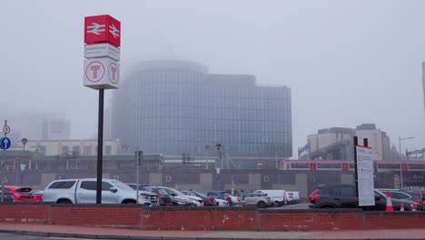 Cardiff-train-station-on-a-foggy-winter's-day,-a-train-leaves-the-station