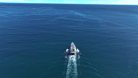 Fishing-Vessel-Sailing-Across-The-Ocean-In-Skrudur-Island,-Faskrudsfjordur,-East-Iceland---aerial-drone-shot
