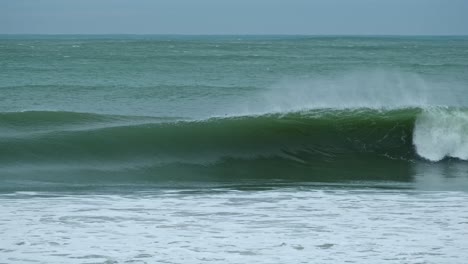 Surfer-paddling-over-blue-big-ocean-wave