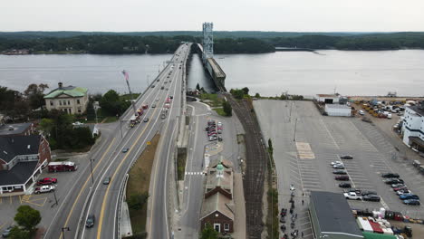 Forward-drone-flight-beside-Route-1-in-the-City-of-Bath-Maine,-showing-flowing-traffic-over-Bridge