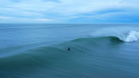 Nicht-Erkennbarer-Surfer,-Der-Im-Ozean-Mit-Großen-Wellen-Schwimmt