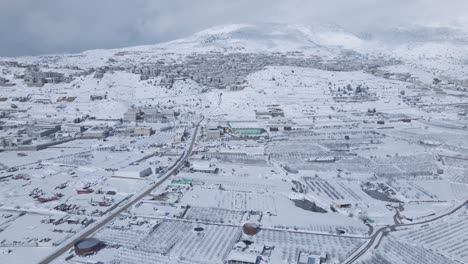 aerial-shot-of-a-snow-covered-Ramat-Hagolan-with-Mt-Hermon-in-the-background,-Israel