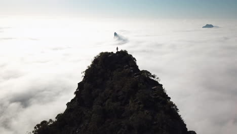 Glasshouse-Mountain-early-morning-drone-views-of-hiker-walking-above-the-clouds-Queensland