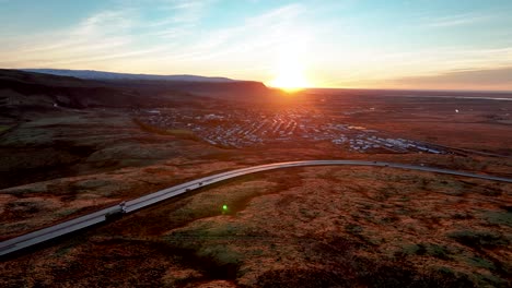 Aerial-View-Of-Hveragerdi-Town-And-Road-Number-One-During-Sunrise-In-South-Iceland---drone-shot