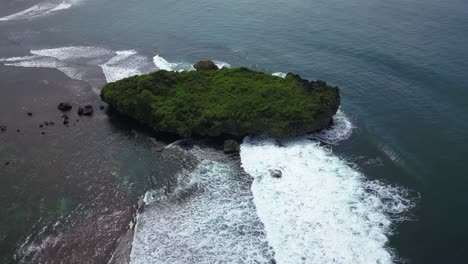 Aerial-view-of-tropical-beach-with-blue-water-and-waves-crashing-coral-rock