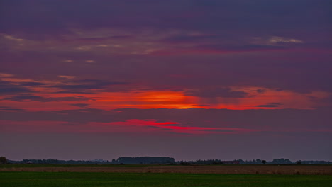 Time-lapse-of-a-colorful-sunrise-over-the-farmland-fields-and-forest---dawn-of-a-new-day