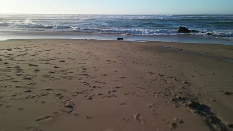 From-sand-to-water-on-Carmina-Beach---Cascais,-Portugal