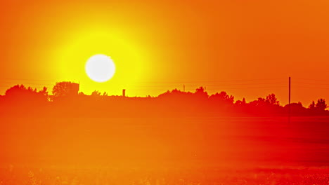 Fiery,-golden,-glowing-sunset-on-a-hazy-evening-in-the-countryside---time-lapse