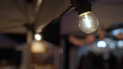 Lit-Light-Bulb-at-Night-Outdoor-Market---Close-up
