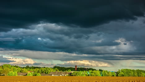 Dark,-stormy-clouds-blowing-across-the-sky-above-a-farmland-field-or-freshly-planted-crops---dramatic-cloudscape-time-lapse