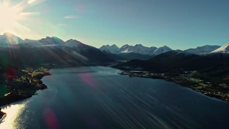 Aerial-drone-cinematic-flying-over-Fjord-with-town-houses-along-mountain-slope-in-Norway-on-a-bright-sunny-day
