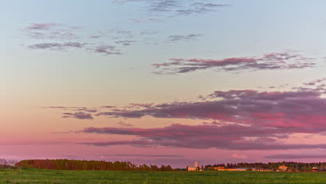 Time-lapse-of-pink,-purple,-orange,-and-blue-sunset-at-an-open-field-in-countryside